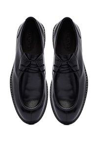 Zwarte leren schoenen met een gladde textuur, ronde neus, decoratieve veters en een contrasterende, gestructureerde zool. Bevat een logo op de binnenzool.
