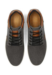 Graue Stoffturnschuhe mit braunen Lederakzenten, runder Zehenform, schwarzen Schnürsenkeln und weißen Gummisohlen. Textiloberseite und gepolsterte Innensohlen.