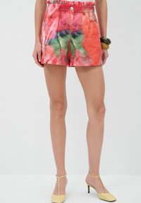 Bermudas multicolores con un patrón floral en acuarela, que cuentan con una cintura fruncida y un cierre de botón en la parte delantera. Fabricadas en tejido ligero.