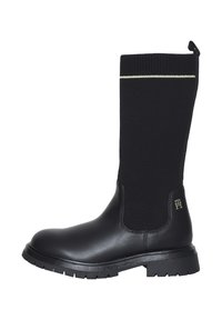 Stivali neri alti fino al ginocchio con parte inferiore in pelle e parte superiore in maglia, con logo con accento dorato e suola testurizzata per una presa migliore.