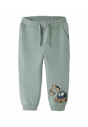 Pantalon de survêtement pour enfants vert clair avec taille élastique, cordon de serrage, poches latérales et une pelleteuse de dessin animé imprimée sur une jambe.