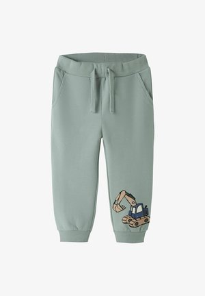 Pantalon de survêtement pour enfants vert clair avec taille élastique, cordon de serrage, poches latérales et une pelleteuse de dessin animé imprimée sur une jambe.