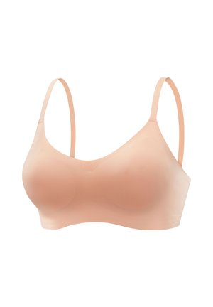 Light peach wireless bra made of smooth fabric. Features thin, adjustable straps and a seamless design with soft cups for comfort.