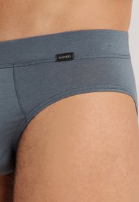 Grijze katoenen slip met een snug fit, voorzien van een logo-label op de tailleband en een gladde textuur. Het ontwerp benadrukt comfort en eenvoud.