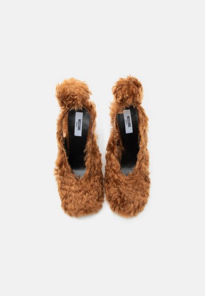 Ζευγάρι καφέ χνουδωτά παπούτσια με ψηλό τακούνι, στρογγυλεμένες μύτες και λεπτομέρεια φιόγκου στην κορυφή, μαύρο εσωτερικό πέλμα και λογότυπο Moschino στο εσωτερικό.