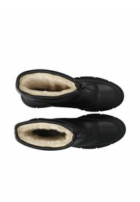 Botas de invierno aisladas negras con forro suave color crema, forma redondeada, parte superior texturizada y cierre ajustable con cordón en la parte superior.