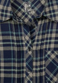 Plaid skjorte med navy, grå og teal farver. Knappelukning foran med en brystlomme og krave. Blød, flanel-lignende tekstur.
