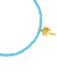 Mėlynas karoliukų apyrankė su mažyte auksine palmių medžio pakabuku ant balto fono.