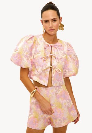 Haut court à manches courtes avec un motif floral en rose et jaune, doté de manches bouffantes, d'une ouverture nouée et d'un short assorti. Tissu texturé avec un motif floral.