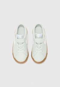 Ανοιχτό πράσινα αθλητικά παπούτσια με λευκές λεπτομέρειες, υφασμάτινο συνθετικό υλικό, σχέδιο με κορδόνια, λουρί με βέλκρο και σόλα από καουτσούκ.