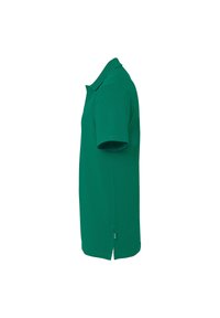 Grøn polo t-shirt lavet af bomuld, med klassisk krave, korte ærmer og en lige syning med sideslids for komfort og let bevægelse.