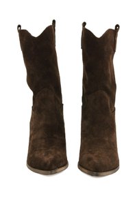 Stivaletti in suede marrone alla caviglia con punta appuntita e bordo scallop. Presentano due linguette superiori per facilitarne l'uso. Suola piatta in metallo.