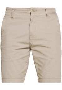 Shorts en coton beige avec une coupe droite, fermeture par bouton et passants pour ceinture. Présente des poches avant et des détails de couture subtils.
