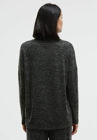 Dark gray oversized sweater in a textured knit, featuring long sleeves and a round neckline, with a relaxed fit, shown from the back.