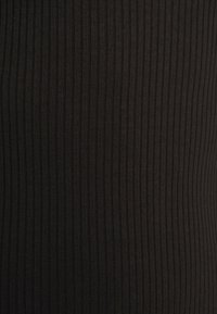 Svart ribbad tyg med vertikal textur, som visar en slät yta och ett konsekvent mönster över ytan. Lämplig för figurnära plagg.