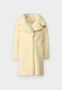 Cappotto in shearling di colore crema con ampio colletto, maniche lunghe e vestibilità morbida. Presenta una texture soffice e nessuna chiusura visibile.