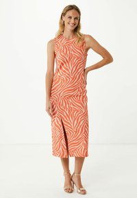 Abito midi arancione con motivo zebra, design senza maniche, spacco laterale e tessuto morbido, abbinato a tacchi dorati a strisce.
