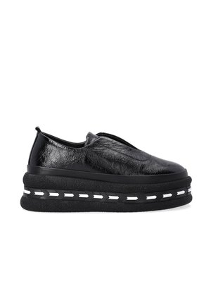 Chaussures noires à enfiler en matériau brillant avec une semelle épaisse et plate-forme, dotées d'une finition texturée et de détails de couture diagonale blanche.