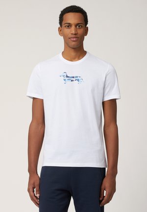 Witte katoenen T-shirt met een grafisch ontwerp van een blauwe en turquoise teckel. Klassieke ronde halslijn en korte mouwen. Eenvoudig, ongecompliceerd ontwerp.
