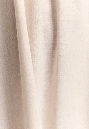 Tela de color beige claro con un tejido texturizado, que muestra variaciones sutiles en el color y ligeras arrugas, creando una apariencia suave y caída.