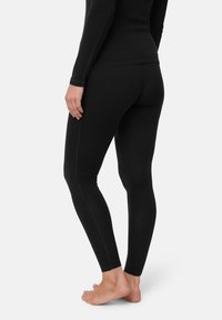 Leggings neri con un design attillato, realizzati in un materiale liscio. Presentano cuciture visibili lungo i lati e una vita a mezza altezza.
