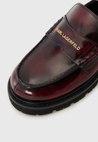 Burgundowe lakierowane loafersy z teksturowaną bandą i złotym logo "KARL LAGERFELD"; cechują się czarną gumową podeszwą i detalami w szwie.