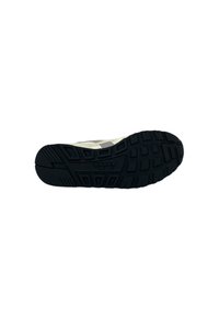 Suola di sneaker in gomma nera con motivo di battistrada testurizzato, presentante una tomaia di un beige chiaro e accenti grigi. Design leggero per il comfort.