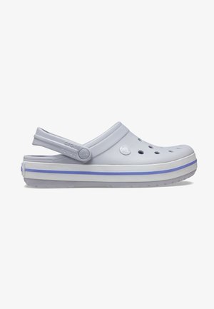 Crocs gris clair avec bout fermé, découpes circulaires et une bride à l'arrière. Caractérisés par des accents violets et une semelle texturée.