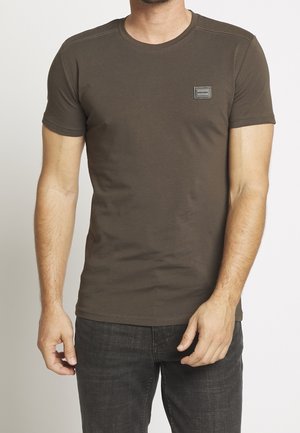 T-shirt med korte ærmer og rund hals i mørk olivengrøn bomuld. Har et lille vævet label på brystet og en glat tekstur.