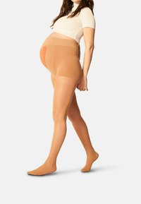 Collant da gravidanza trasparenti color nude con vita alta, texture liscia e design di supporto, progettati per il massimo comfort durante la gravidanza.