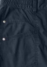 Shorts en tissu bleu marine foncé avec une taille élastique, dotés de deux poches plaquées avec des coutures décoratives et des accents de boutons-pression en métal à l'arrière.