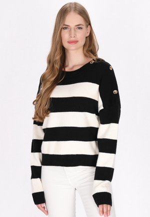 Maglione a strisce bianche e nere con scollatura tonda, texture a maglia, vestibilità oversize e dettagli con bottoni dorati sulla spalla.