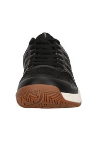 Svarta sportskor med ovandel i mesh, rund tå och brunt gummisul. Har svarta snören och en vit detalj på sulan.