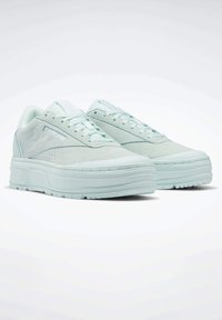 Jasno miętowe sneakersy wykonane z zamszu i gumy, z okrągłym noskiem, płaskimi sznurowadłami oraz warstwową podeszwą platformową z teksturowanymi akcentami.