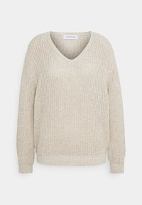 Svetr s výstřihem do V a dlouhými rukávy vyrobený z pletené béžové látky s texturovaným vzorem; má žebrovaný lem a manžety.