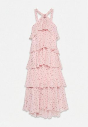 Robe rose à fleurs à volants superposés, bretelles croisées dans le dos et détail en forme de rose en tissu sur la poitrine.