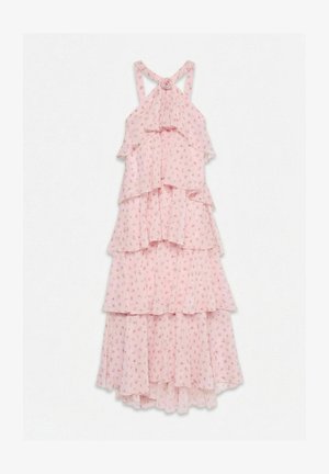 Robe rose à fleurs à volants superposés, bretelles croisées dans le dos et détail en forme de rose en tissu sur la poitrine.