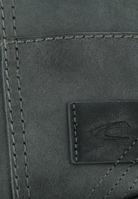 Black leather wallet with visible stitching, textured surface, and a small logo patch featuring a simplified design on the front.