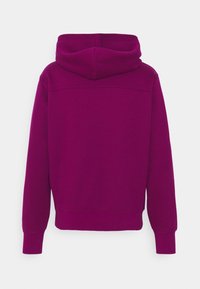 Felpa con cappuccio fucsia dal taglio morbido, con polsini e orlo a coste. Tessuto dalla texture liscia e dettagli di cuciture minimi sul retro.