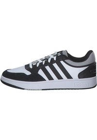 Czarno-białe sportowe trampki z okrągłym noskiem, górą z materiału, trzema czarnymi paskami i gumową podeszwą; posiadają sznurowane zapięcie z przodu oraz wyściełany kołnierz.