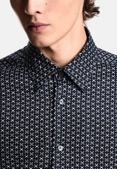 Camicia nera con bottoni e design a motivi bianchi con piccoli elementi decorativi. Tessuto morbido e intrecciato, colletto alla francese e chiusura con bottoni standard.