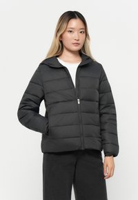 Puffjakke i ensfarget svart, med glidelås foran, hette og quiltet design med horisontale seksjoner. Lange ermer med elastiske mansjetter.