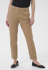 Pantalons habillés kaki avec une coupe slim, dotés d'une texture lisse, de passants de ceinture, de poches avant et d'un design à chevilles raccourcies. Assortis à des ballerines noires.