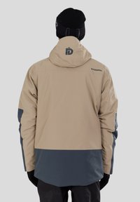 Béžová a šedá bunda s kapucí s hladkou texturou, na zadní straně s logem, elastickými manžetami a kontrastními barevnými bloky.