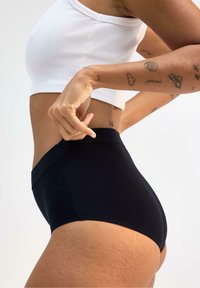 Hög midja svarta shorts tillverkade av stretchigt material, med en slät yta och en minimalistisk design utan synliga sömmar.