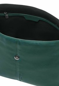 Zielona skórzana torebka z magnetycznym zapięciem, czarnym materiałowym wnętrzem i kieszenią na zamek z napisem "Liebeskind Berlin".