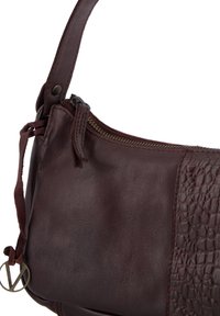 Brown leather shoulder bag featuring a textured panel, zipper closure, and a flat leather strap with an accent. Smooth and structured design.