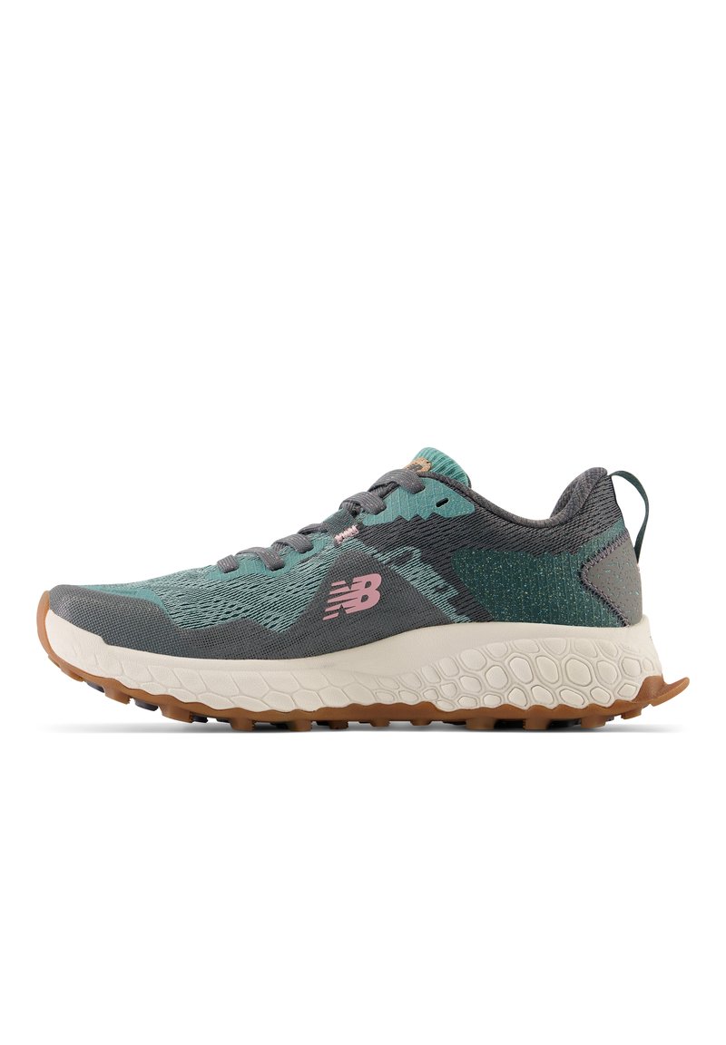 Graue und tealfarbene New Balance Laufschuhe mit pinkem Logo, strukturiertem weißen Zwischensohlen und robustem braunem Außensohl, Seitenansicht.