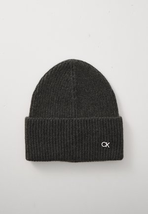 Tumši pelēko ribota adījuma cepure ar loka malu, kurai ir neliels sudraba "CK" logotips uz vienkārša gaismas fona.