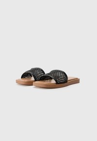 Svarte vevde slidesandaler med flat tresåle, som har åpen tå og brede stropper for ventilasjon og komfort.